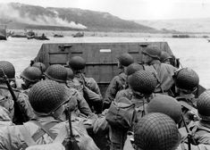 a group of soldiers on a boat in the water with their backs turned to the camera