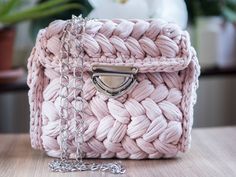 a pink purse sitting on top of a wooden table