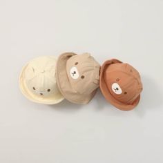 three hats with teddy bears on them sitting next to each other