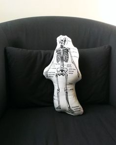 a skeleton pillow sitting on top of a black couch