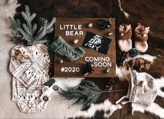 a baby's first christmas outfit and other items are laid out on a fur rug