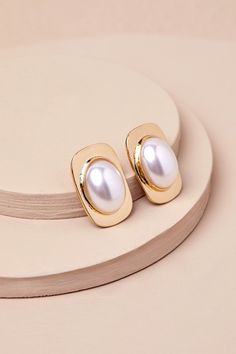 Timeless and attention-worthy, the Lulus Stunning Muse Gold Pearl Statement Earrings will be the perfect finishing touch to any outfit! These shiny, gold-toned metal earrings have a chic, vintage-inspired design with a rectangular silhouette and an oversized, glowing faux pearl that sits at the center. Post backs. Earring Measure 1. 25" Long And 0. 75" Wide. 85% Brass, 15% Acrylic Pearl. Imported. Lulus | Stunning Muse Gold Pearl Statement Earrings. Classic Gold Metal Pearl Earrings, Classic Gold Earrings For Party, Chic Gold Clip-on Earrings For Anniversary, Chic Gold Clip-on Pearl Earrings, Gold Chic Pearl Earrings For Formal Occasions, Classic Gold Pearl Earrings For Party, Chic Gold Pearl Earrings For Formal Occasions, Gold Metal Pearl Earrings For Anniversary, Pearl Statement Earrings