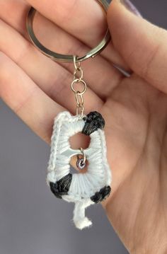 a hand holding a keychain with a black and white dog on it