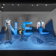 the window display features mannequins dressed in blue and white