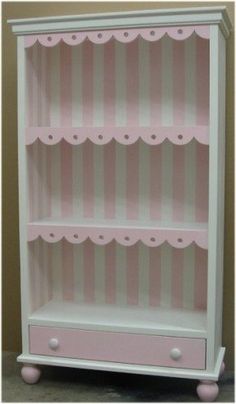 a pink and white bookcase sitting on top of a floor