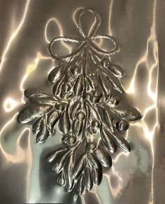 an image of a christmas decoration made out of silver foil on a shiny table cloth