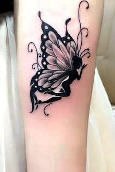 a black and white butterfly tattoo on the arm