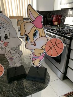 two paper cutouts of cartoon characters on a kitchen counter