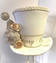 "This stunning ivory and gold tree topper top hat and/or centerpiece is sold, but no worries, we can make one just for you. This top hat can be used as a Christmas tree Topper or a Christmas decoration centerpiece. Made with ivory canvas fabric and decorated in ivory and gold.   🎄 Measures about 9.5\" tall (not including the picks) x 12\" at the brim Our top hat tree toppers/centerpieces are 100% handmade by us with high-quality materials. The designs are our own unique design. Our top hat tree Christmas Tree Topper Candy, Ivory Christmas Tree, Top Hat Centerpieces, Silver Tree Topper, Snowman Tree Topper, Peppermint Ornament, Gold Tree Topper, Dt Crafts, Hat Tree