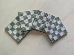 four pieces of green and white woven coasters