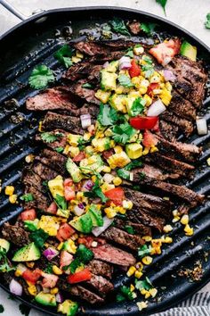 grilled steak with corn, avocado and salsa on the grill top in a cast iron skillet