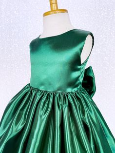 A classic and simple but beautiful full satin dress that's perfect for any formal occasion: weddings, graduations, birthdays, or holidays! Handcrafted with the upmost of care and attention to detail, we make sure that each dress is perfectly one of a kind for your little girl. Comfortable satin material covers the dress from shoulder to hem. The sleeveless top has a zipper on the back for closure. Comes with a detachable matching bow with tails. The skirt has a layer of lining underneath with at Fitted Sleeveless Christmas Ball Gown, Sleeveless Christmas Dress With Bow, Christmas Wedding Princess Dress With Bow, Sleeveless Ball Gown For Christmas Wedding, Elegant Sleeveless Green Princess Dress, Elegant Green Holiday Dress For Wedding, Elegant Christmas Ball Gown, Christmas Pageant Sleeveless Holiday Dress, Sleeveless Christmas Pageant Holiday Dress