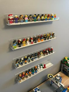 three shelves with legos on them are hanging from the wall in front of a table