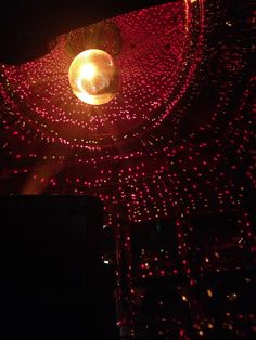 a disco ball is lit up in the dark with red and white lights on it