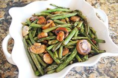 a white bowl filled with green beans and mushrooms