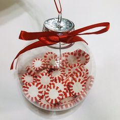 a glass ornament with red and white candy canes in it