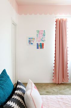 a bedroom with pink and blue decor on the walls, bed linens and pillows