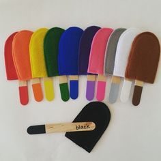 an assortment of colorful ice cream popsicles and spatulas with wooden handles on white background