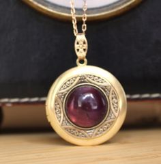 This raw brass locket has been layered with a vintage brass bezel  and set with a lovely 16mm Amethyst Gemstone cabochon.  It has been polished to a warm golden tone and sealed with a wax polish.  In time it will darken but can be polished back to golden or left to form its natural patina if desired. The locket is 30mm with 10mm bail and is hung from a matching 1x2mm brass link chain and finished with a brass lobster clasp. It will arrive in a velvet gift pouch. Antique Cabochon Necklace With Round Pendant, Antique Cabochon Round Pendant Necklace, Vintage Cabochon Jewelry For Vintage Collection, Brass Cabochon Jewelry For Jewelry Making, Bronze Round Brass Locket Necklace, Vintage Antique Gold Cabochon Jewelry, Vintage Brass Necklaces With Cabochon, Victorian Round Necklace With Antique Finish, Antique Oval Cabochon Gemstone Necklaces