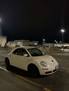 a white car parked in a parking lot at night