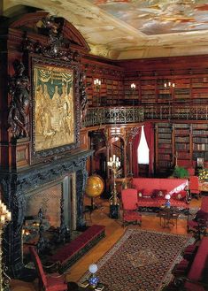 a living room filled with lots of furniture and bookshelves covered in intricately painted ceilings