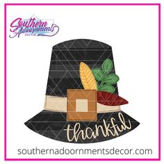 a black hat with the word thanks on it and some leaves in front of it