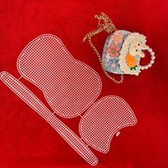 an ornament is laying on top of a red cloth with a white design