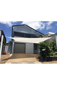 an image of a house that is in the middle of some bushes and trees with a white awning over it