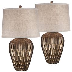 two lamps are sitting next to each other on a white background, one is brown and the other is beige