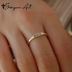 a woman's hand with a gold wedding ring on her finger and the date written in cursive writing