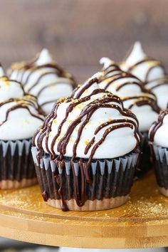 chocolate cupcakes with white frosting and sprinkles on a wooden platter