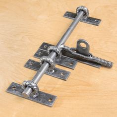 two metal latches are attached to the wooden surface