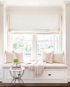 a window seat with pillows and blankets on it