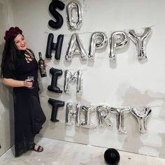 a woman standing in front of balloons that say happy new year and the words so happy to her