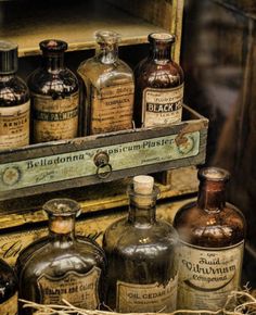 old medicine bottles are lined up in an antique wooden box, with labels on them