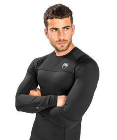 a man with his arms crossed wearing a black wetsuit