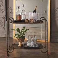 a bar cart with bottles and glasses on it