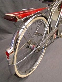 a close up of a bike on a gray background with a red handlebars