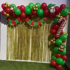 the balloon arch is decorated with green, red and gold balloons