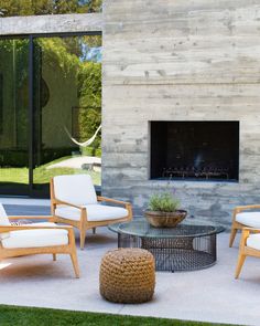 a living room with chairs and a fire place in front of a wall mounted fireplace