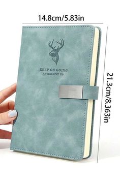 a hand holding a blue notebook with a deer head on the front and bottom cover