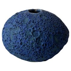 a large blue rock sitting on top of a white surface with holes in the middle