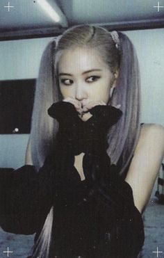 a woman with long blonde hair and black gloves on her face is posing for the camera