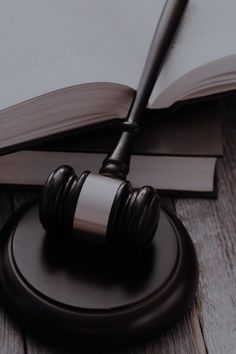 a wooden judge's gavel sitting on top of a table next to an open book