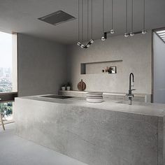 a modern kitchen with an island sink and countertop in the middle, surrounded by hanging lights