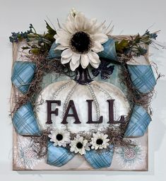 a white and blue fall decoration with sunflowers