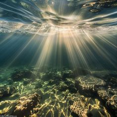 the sun shines through the water as it passes over rocks and under the ocean floor