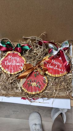 a box that has some kind of christmas decoration in it with ribbon around the top