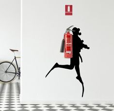 a woman running with a fire extinguisher in her hand and a bicycle leaning against the wall