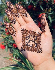 hendi tattoos on the palm of a person's hand with red flowers in the background